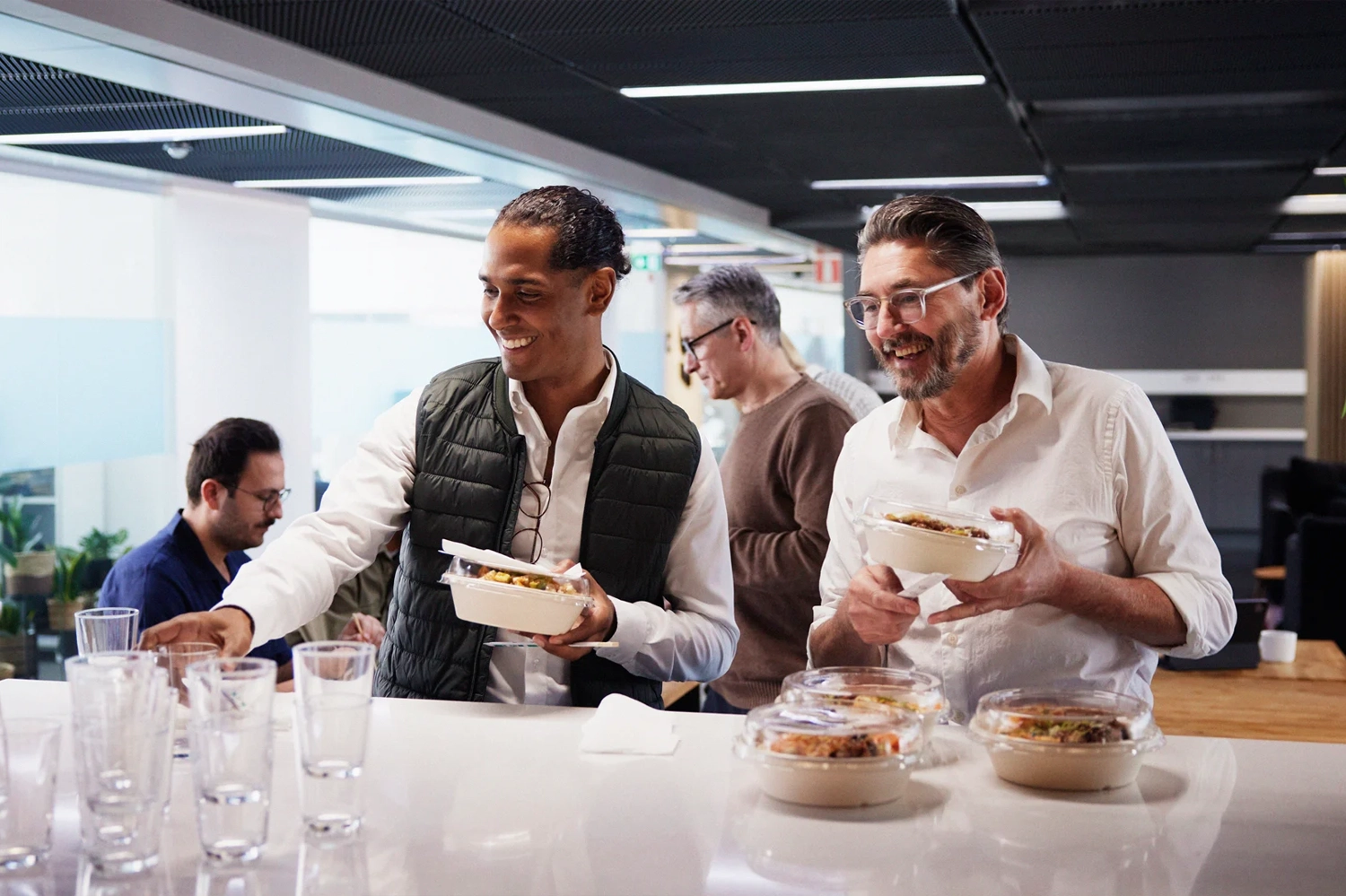 Focused employees enjoying a healthy meal together in a modern office space
